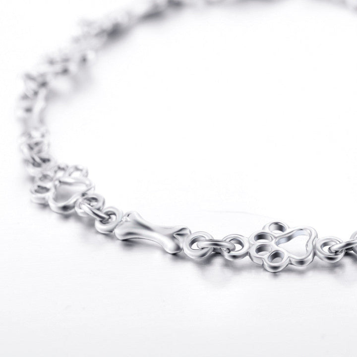 Armband mit Anhänger aus Silber mit Hundepfoten und -knochen